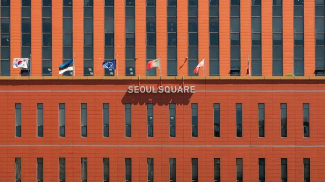 Red facade of Seoul Square with multiple international flags displayed. — lounges at Seoul Incheon Airport