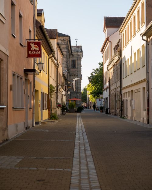 Free Explore a picturesque cobblestone street lined with traditional Bavarian architecture in the warm glow of day. Stock Photo