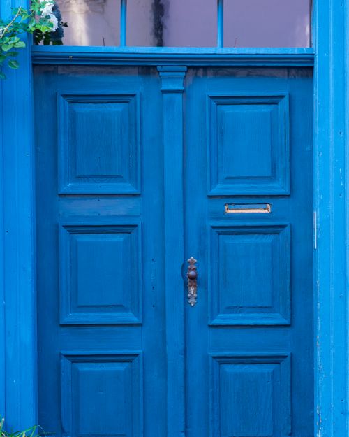 Free Close-up of a classic vibrant blue wooden door with a vintage handle and decorative details. Stock Photo