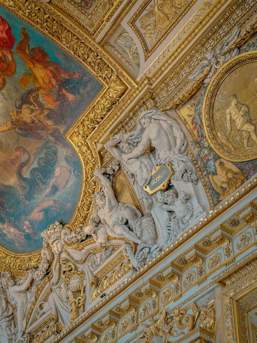 Free Detailed view of intricate Baroque sculptures and frescoes on a grand ceiling. Stock Photo