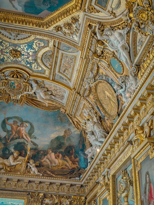 Free Detailed view of a Baroque ceiling with vibrant frescoes and ornate gold decorations. Stock Photo