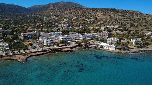 Free A stunning aerial view of the coastal town Stalída in Crete, Greece, showcasing hotels and turquoise waters. Stock Photo