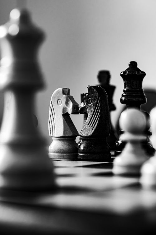 Free Close-up black and white photo of a chessboard highlighting a strategic duel with knights. Stock Photo