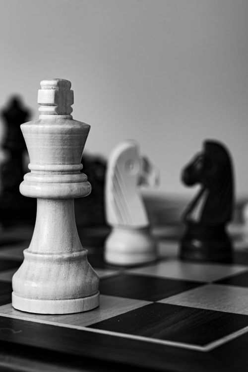 Free A monochrome chessboard with wooden chess pieces in strategic arrangement, emphasizing tactical gameplay. Stock Photo