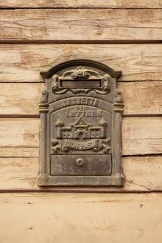 A classic Italian mailbox set against a textured wooden wall, perfect for vintage themes.