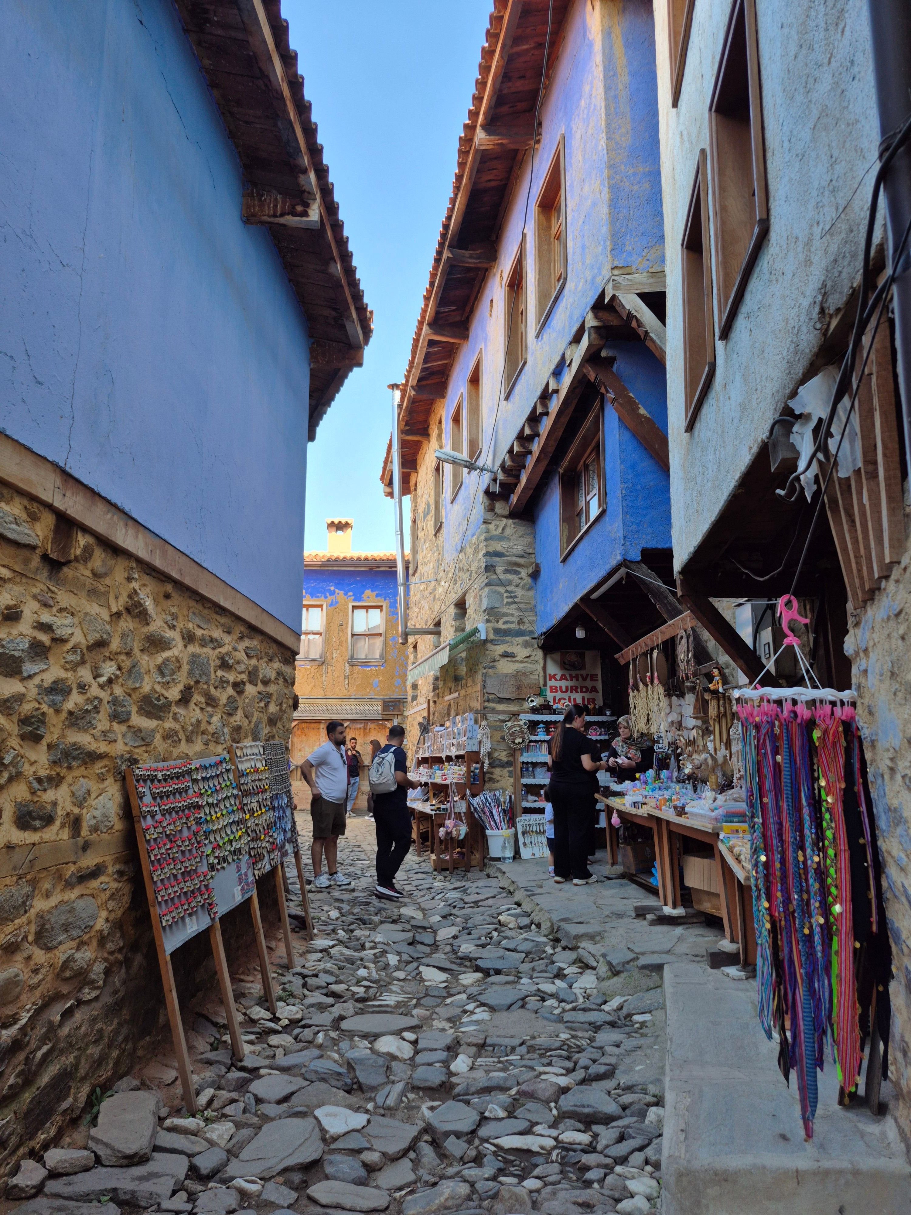 A quaint alley with vibrant market stalls and stone buildings, perfect for exploration.