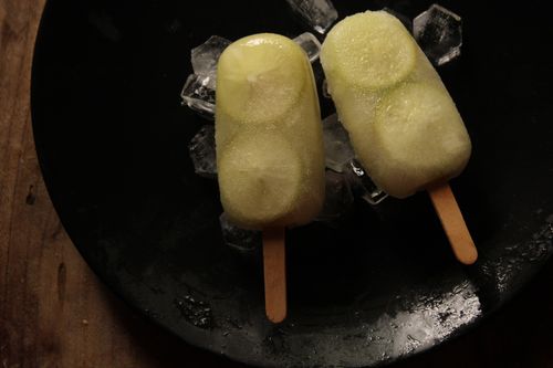 Free Two lemon popsicles on a bed of ice cubes, perfect for a refreshing summer treat. Stock Photo