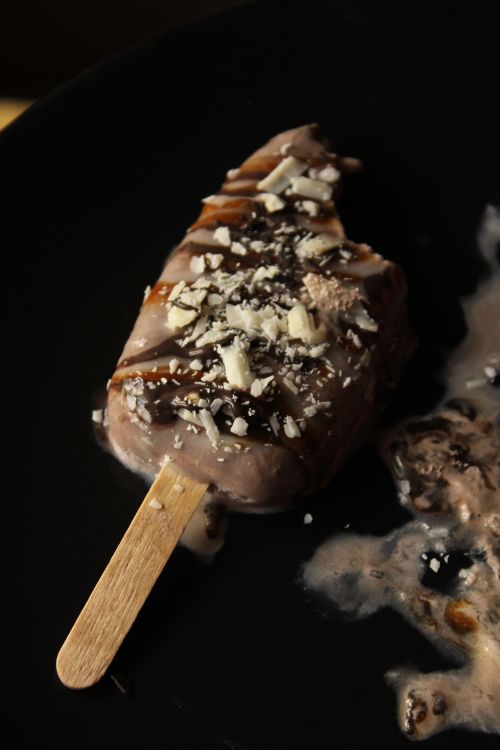 Free Melted chocolate ice cream bar with white chocolate pieces on top. Stock Photo