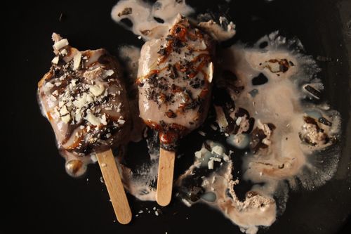 Free Two chocolate ice cream bars melting artistically on a dark background. Stock Photo