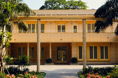 Free Front view of a tropical building with lush green plants and flowers enhancing the ambiance. Stock Photo