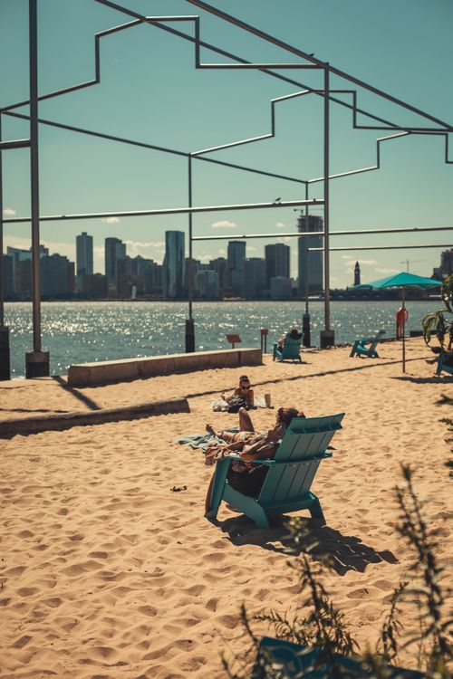 Free Enjoying a sunny day at a beach with city skyline views in the background. Stock Photo