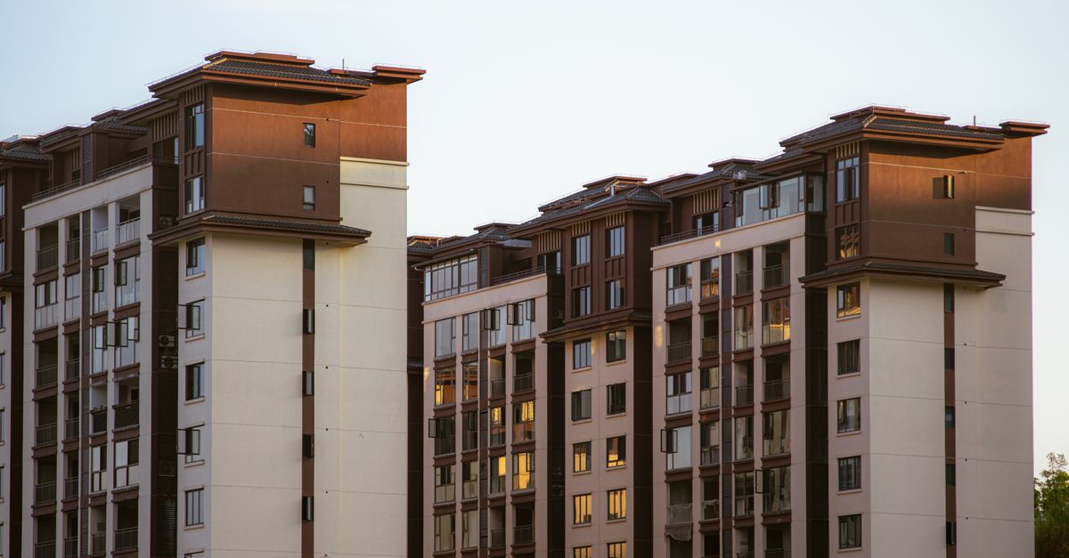 Contemporary apartment buildings with brown and white facade during sunset, showcasing urban architecture.