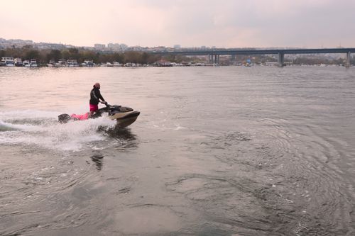 Free Person enjoying a jet ski ride on Istanbul's Bosphorus with cityscape view. Stock Photo