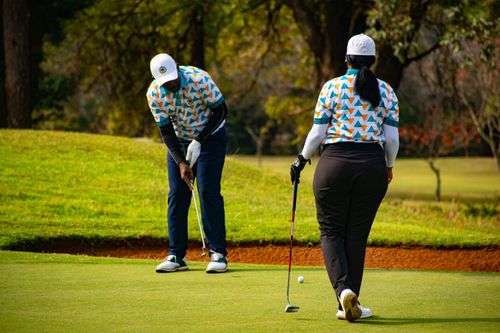 Free Two adult golfers playing on a vibrant golf course in Piggs Peak, Eswatini. Stock Photo
