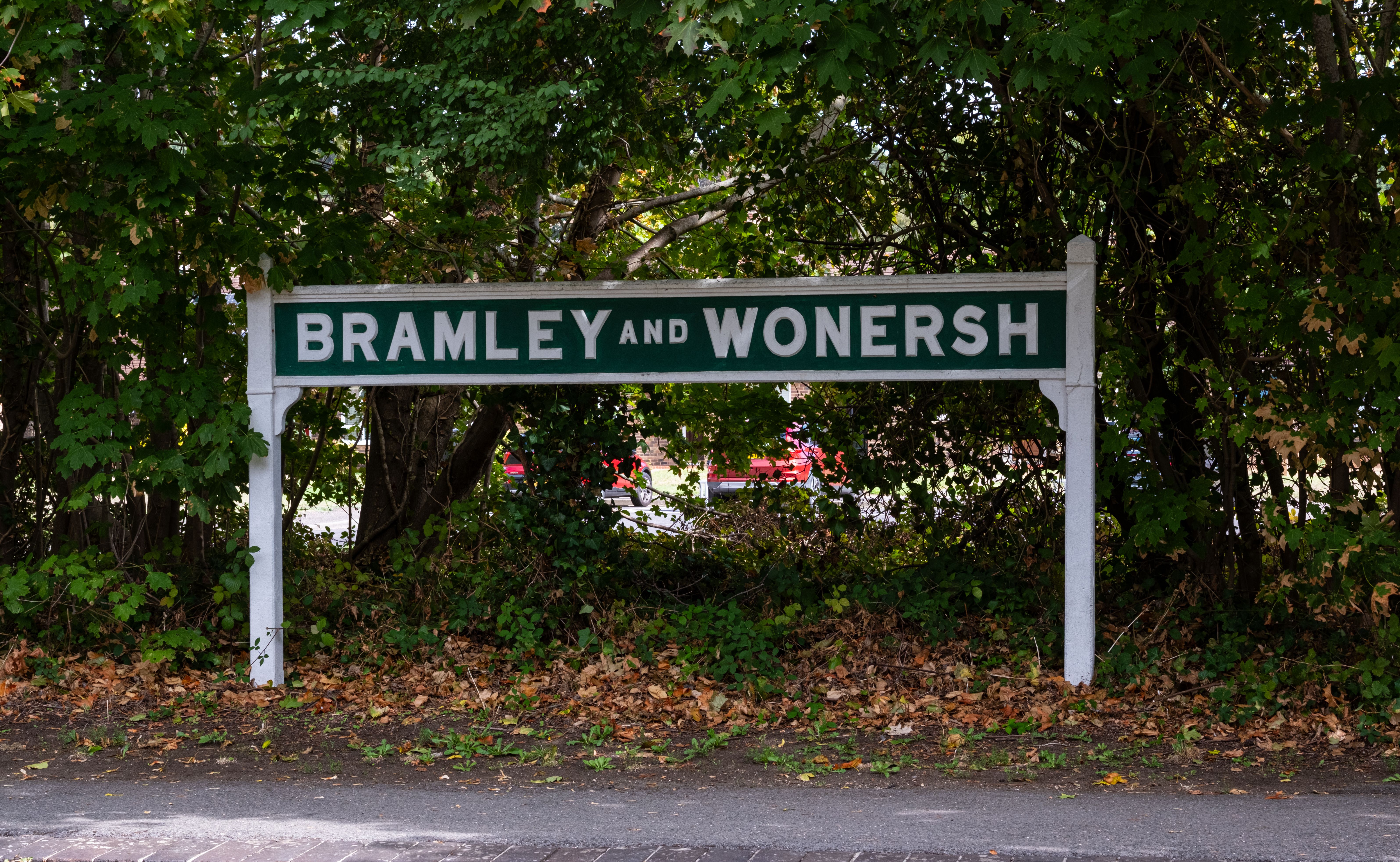 Photo of Bramley and Wonersh village sign surrounded by foliage in Bramley, UK.
