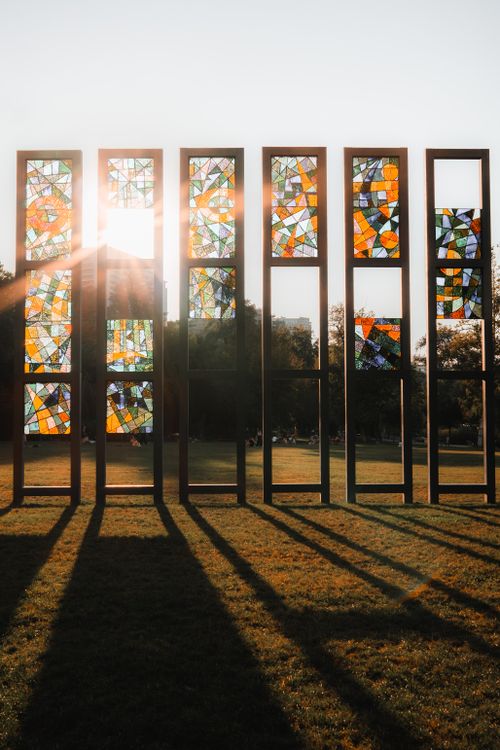 Free Colorful stained glass panels illuminated by sunlight in a park setting. Stock Photo