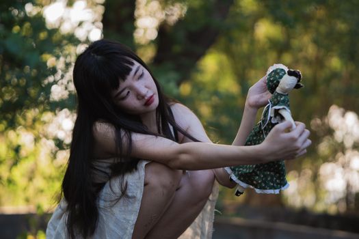 一名年轻女子在户外抱着娃娃，唤起怀旧和内省的主题
