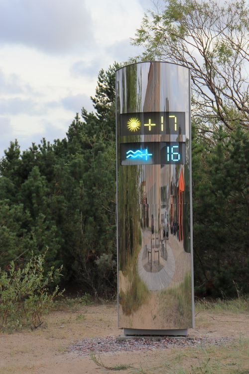 Free Reflective outdoor temperature display amid natural surroundings showing air and water temperatures. Stock Photo