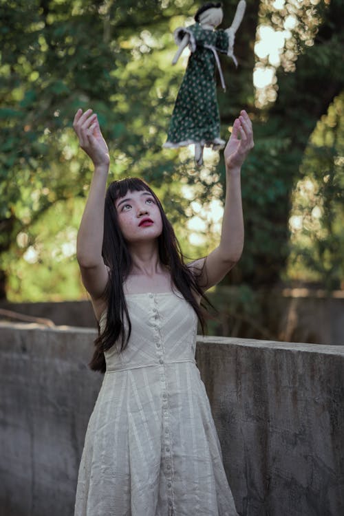 Free Girl In A Dress Throwing A Doll Stock Photo