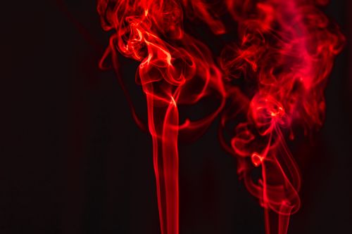 Free Abstract image of dynamic red smoke patterns with vivid contrasts against a dark backdrop. Stock Photo