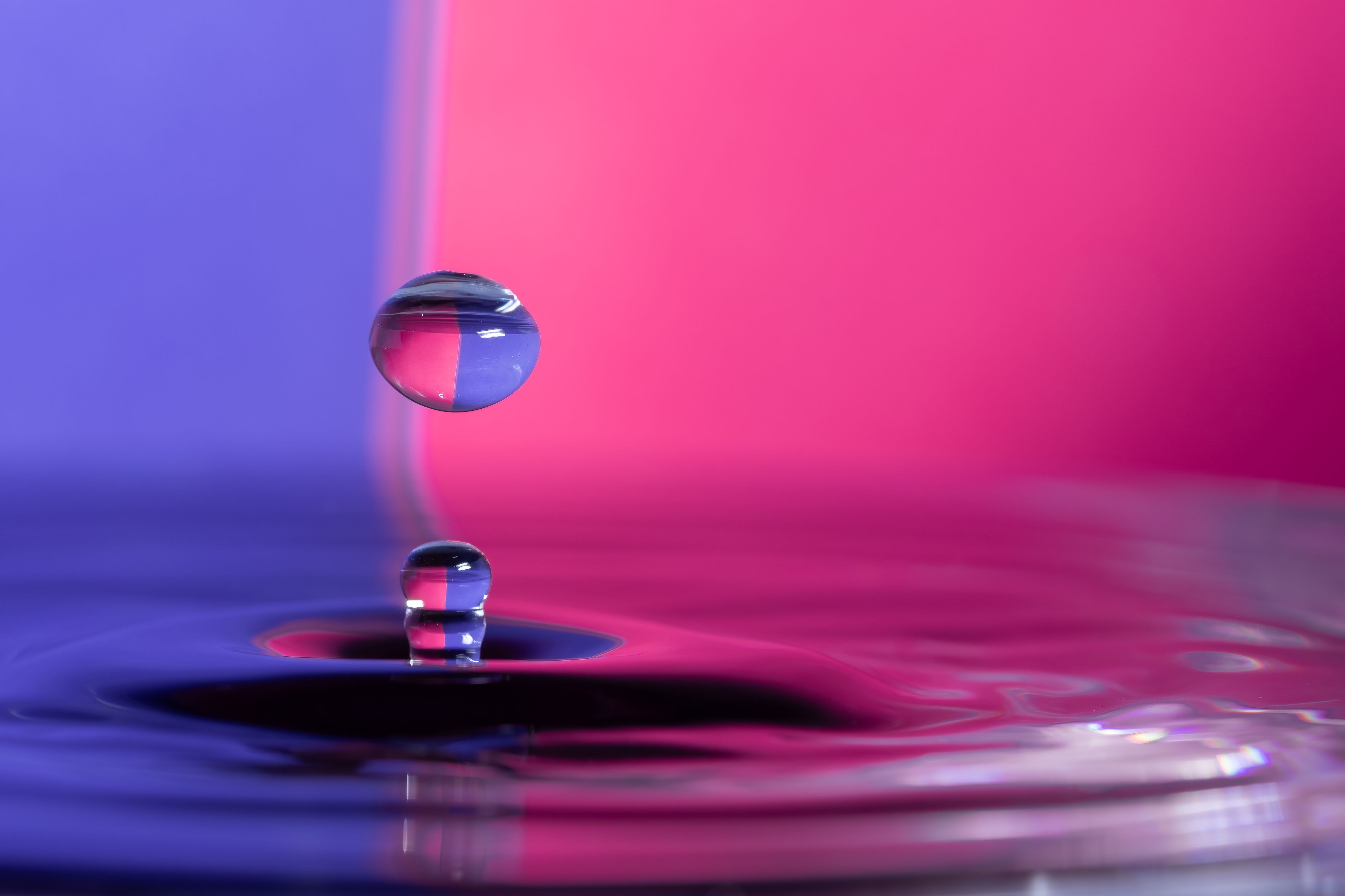 Fotomural Impresionante fotografía macro de una gota de agua salpicando en vivos colores neón, que muestra la belleza de la naturaleza.