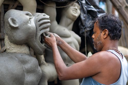 Free A skilled artisan crafts detailed clay sculptures, showcasing traditional artistry in a cultural workshop setting. Stock Photo