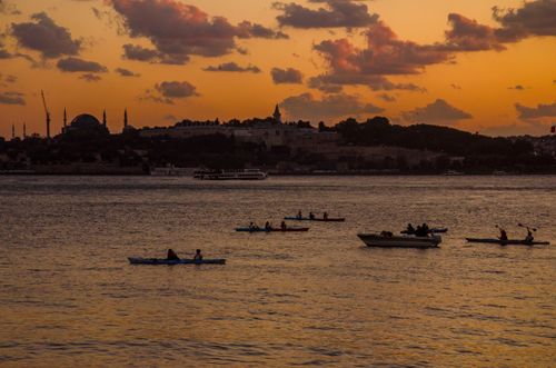 Free Silhouette of kayakers enjoying a sunset on the Bosphorus with İstanbul's skyline in the background. Stock Photo