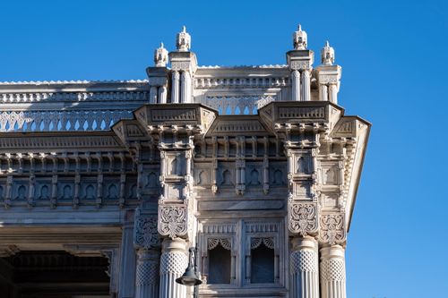 Free Close-up of an intricate historical building facade with detailed carvings set against a clear blue sky. Stock Photo