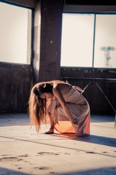 在温暖的室内灯光下，一位女舞者以富有表情的姿势展现了现代舞蹈艺术