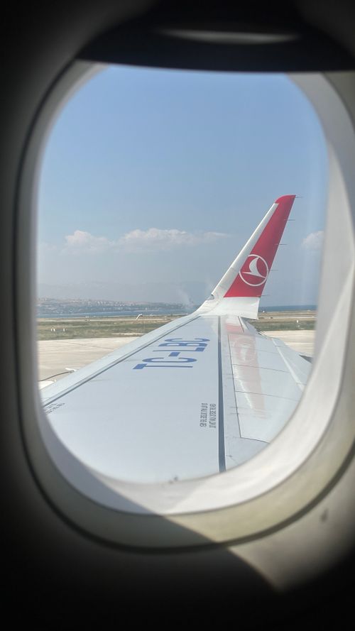 Free View from an airplane window showing the wing and clear skies during daytime flight. Stock Photo