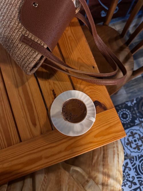 Free Warm ambiance of a cafe featuring a cup of Turkish coffee on a wooden table. Stock Photo
