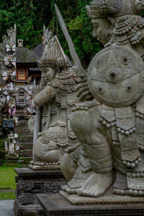 Free Detailed stone statues of guardians in a Balinese temple setting. Stock Photo