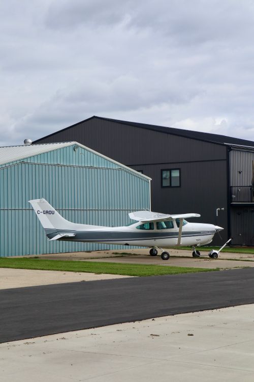 Free A light aircraft parked outdoors beside a hangar in Sherwood Park, Alberta. Stock Photo