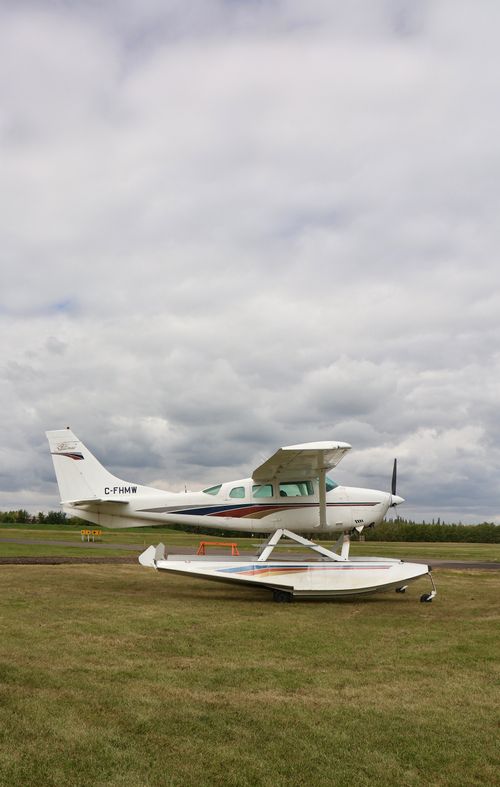 Free A small aircraft sits parked on a green field beneath a cloudy sky in Sherwood Park, Canada. Stock Photo