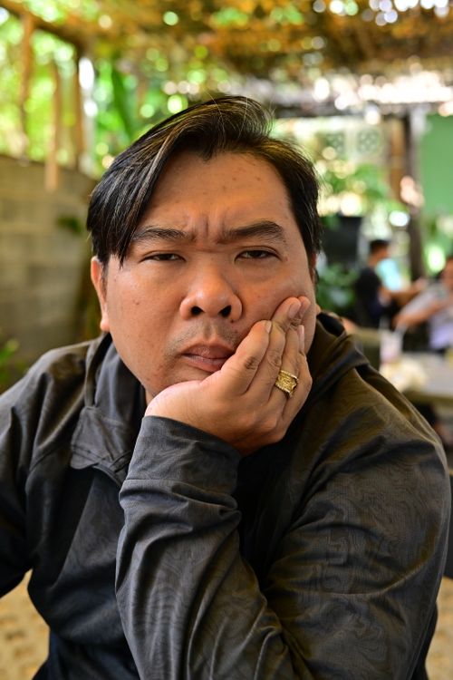 Free A man in a reflective pose at an outdoor cafe setting, wearing a ring. Stock Photo