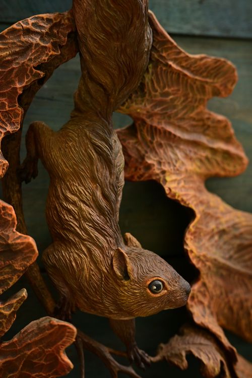 Free Sculpture of a squirrel climbing through detailed autumn leaves. Ideal for rustic and nature themes. Stock Photo