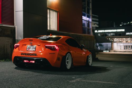 Free Orange sports car parked at night by St. John's Convention Centre. Stock Photo