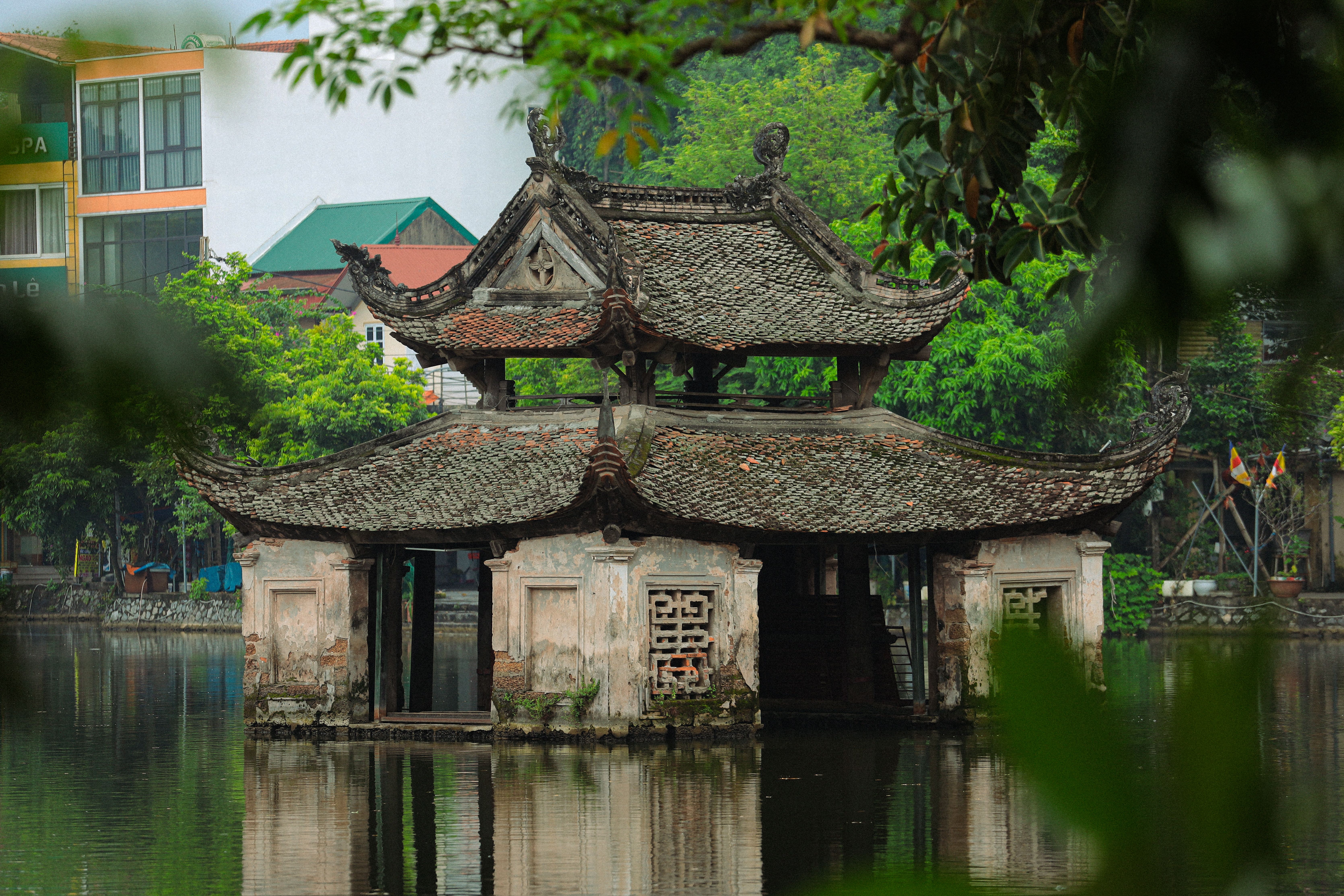 Ancient temple architecture surrounded by lush greenery in Hà Nội, Việt Nam.