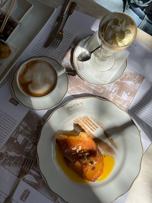 Free A charming cafe scene with cappuccino and dessert, perfect for brunch inspiration. Stock Photo