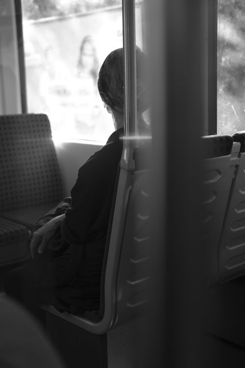 Free A black and white image of a person sitting alone on a train, creating a contemplative mood. Stock Photo
