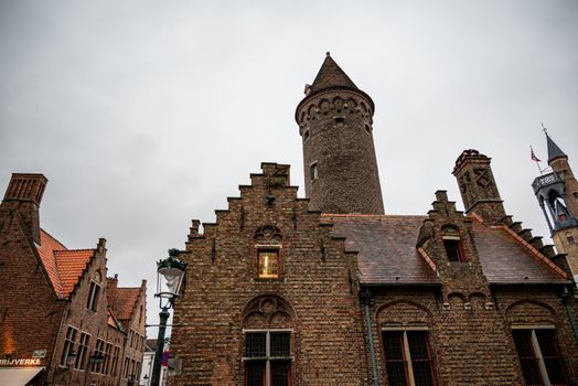 Brick buildings and tower showcasing Flemish architectural style in Bruges, Belgium.