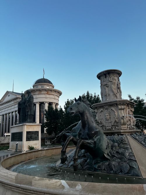 Free A grand historical fountain with horse sculpture in front of a neoclassical building during twilight. Stock Photo