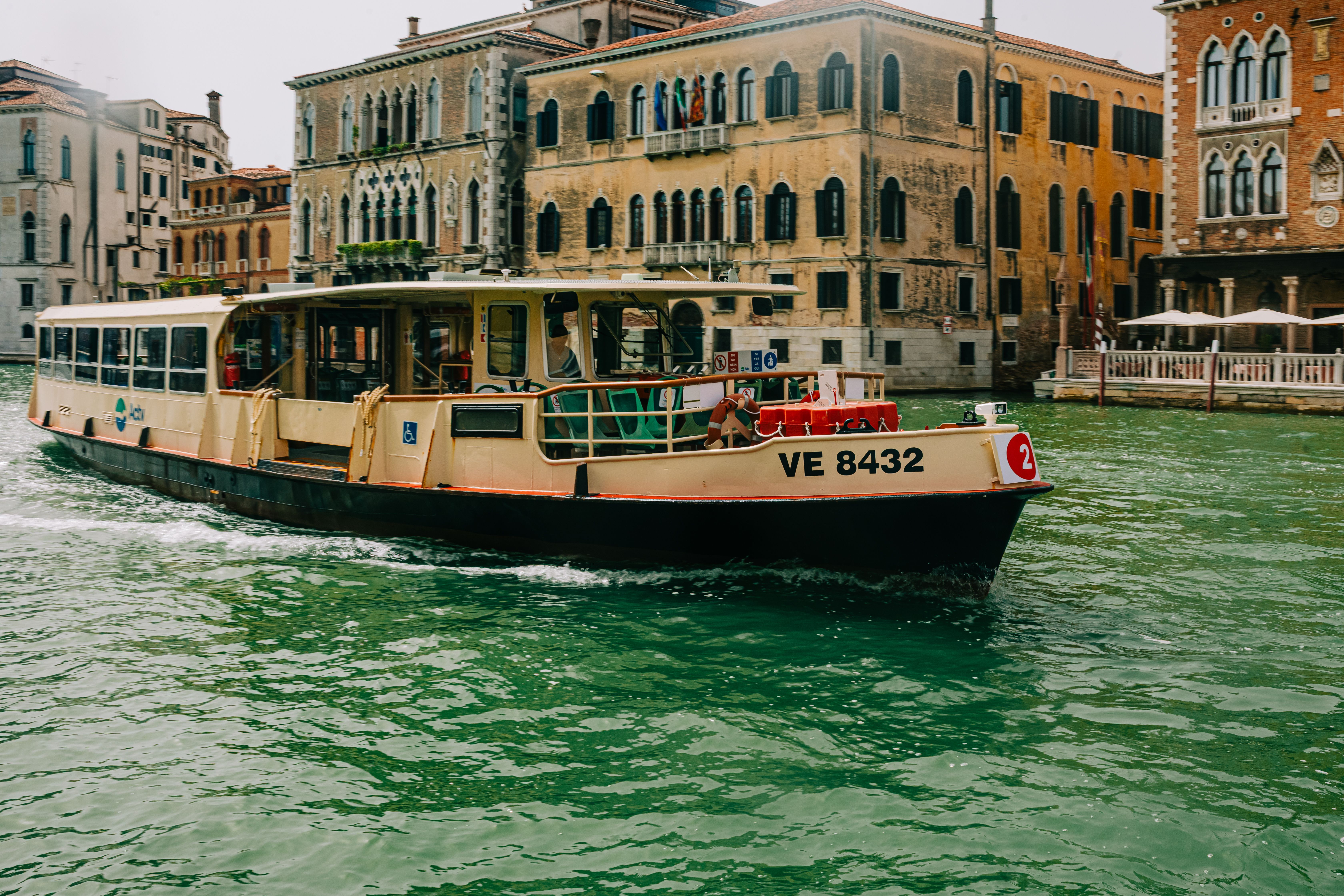 A traditional water taxi travels through the canals of Venice, Italy, showcasing historic architecture.