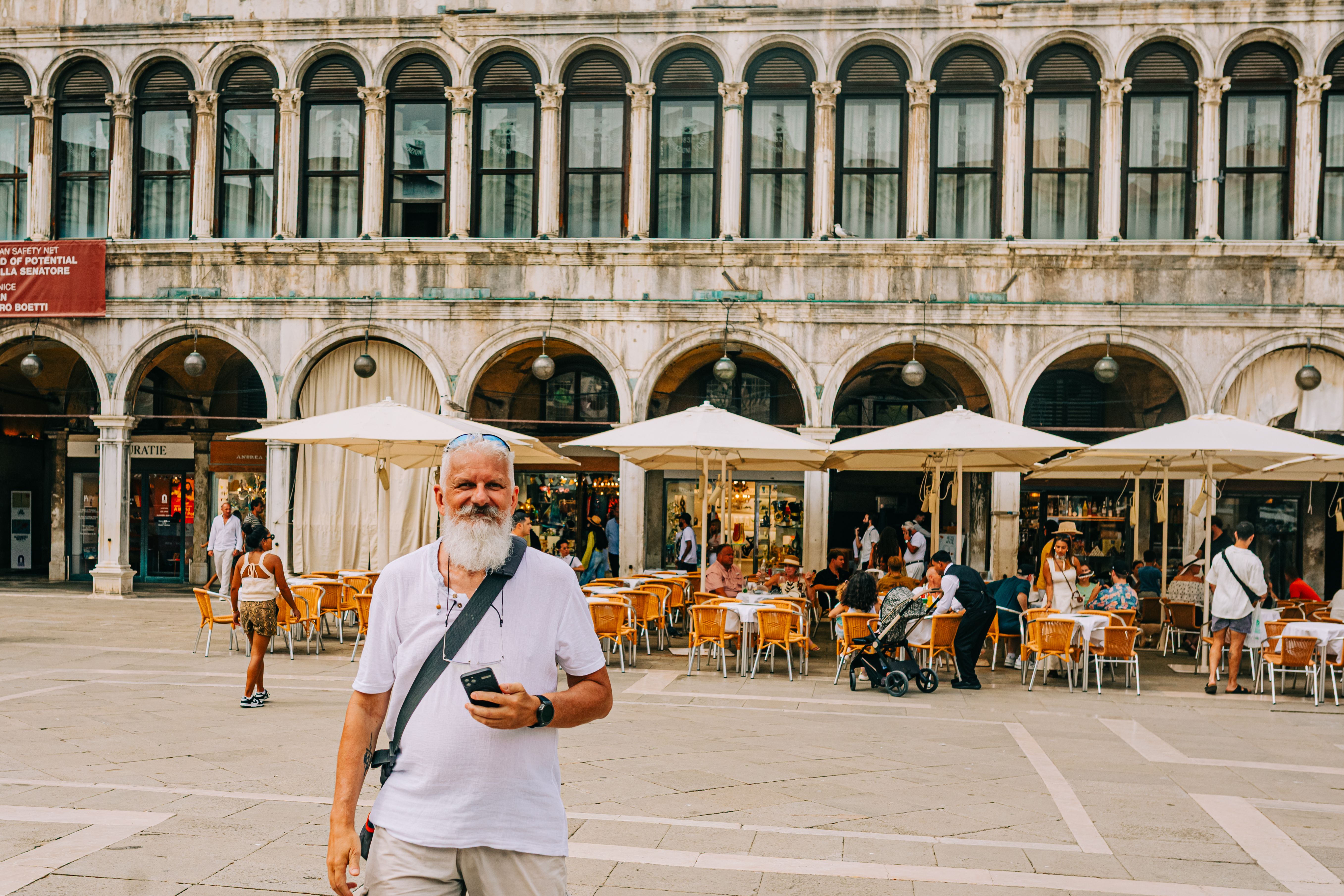 Man standing at Piazza San Marco on a sunny day, capturing Europe's historic charm.