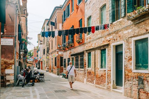 Free Picturesque Venice street scene with colorful buildings, laundry, and local atmosphere. Stock Photo