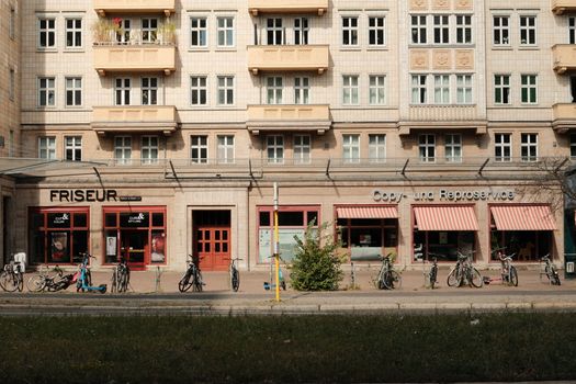 Street view of Berlin with parked bicycles and local shops on a sunny day.
