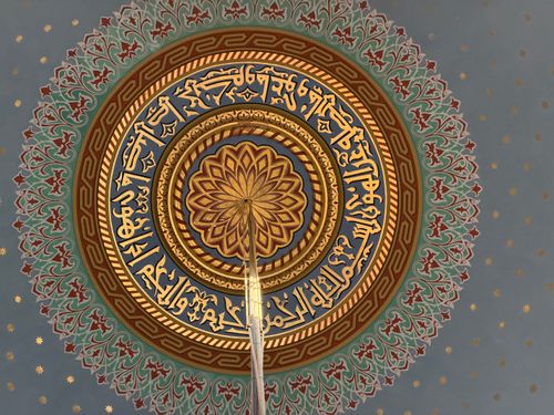 Free Beautifully detailed dome ceiling adorned with Arabic calligraphy and geometric patterns. Stock Photo