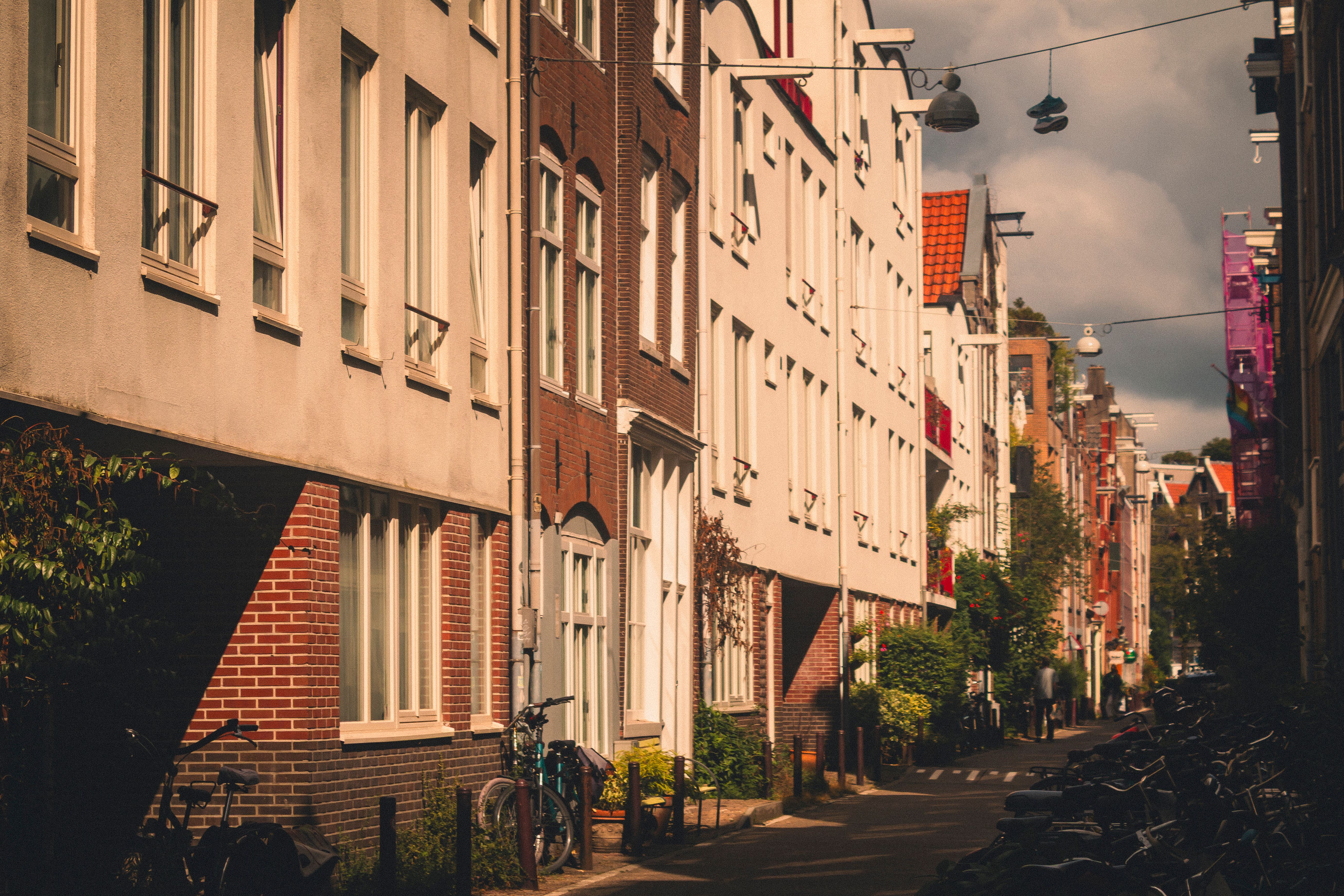 Scenic streetscape of Amsterdam with traditional Dutch architecture and bicycles at dusk.