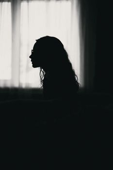 窗边一位女性的黑白剪影，捕捉到一种宁静沉思的氛围。 - 相关推荐