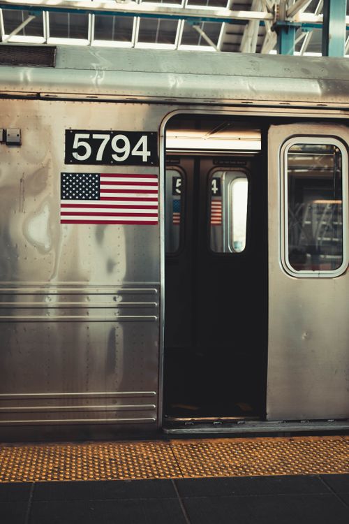 Free A New York City subway car with an open door, featuring the American flag and car number. Stock Photo
